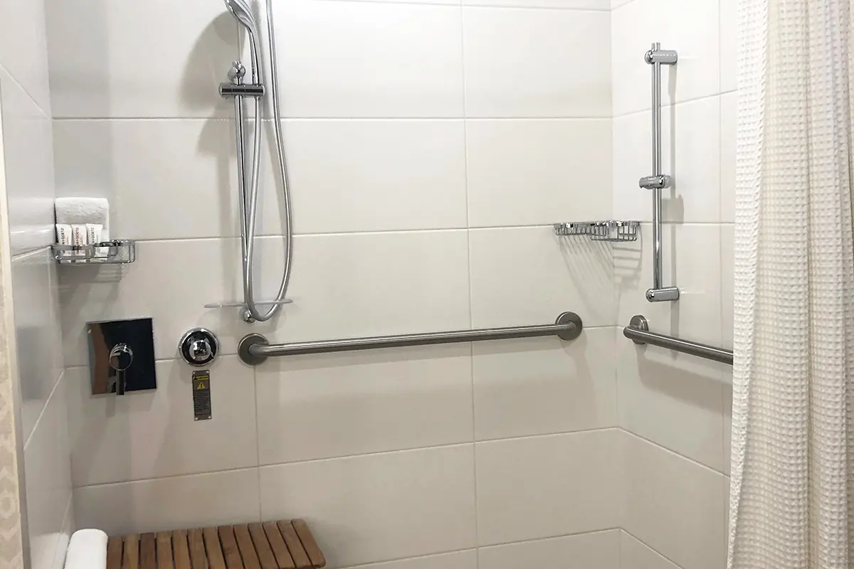 Classic King - mobility-accessible roll-in shower with grab bars, shower seat and hand-held shower wand