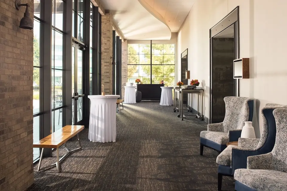 Great Room Foyer - prefunction space with white cocktail tables and a portable bar