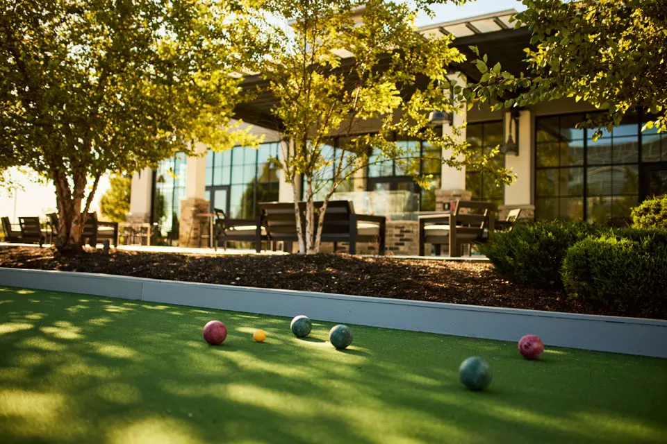 Backyard - bocce ball court with adjacent furnished patio