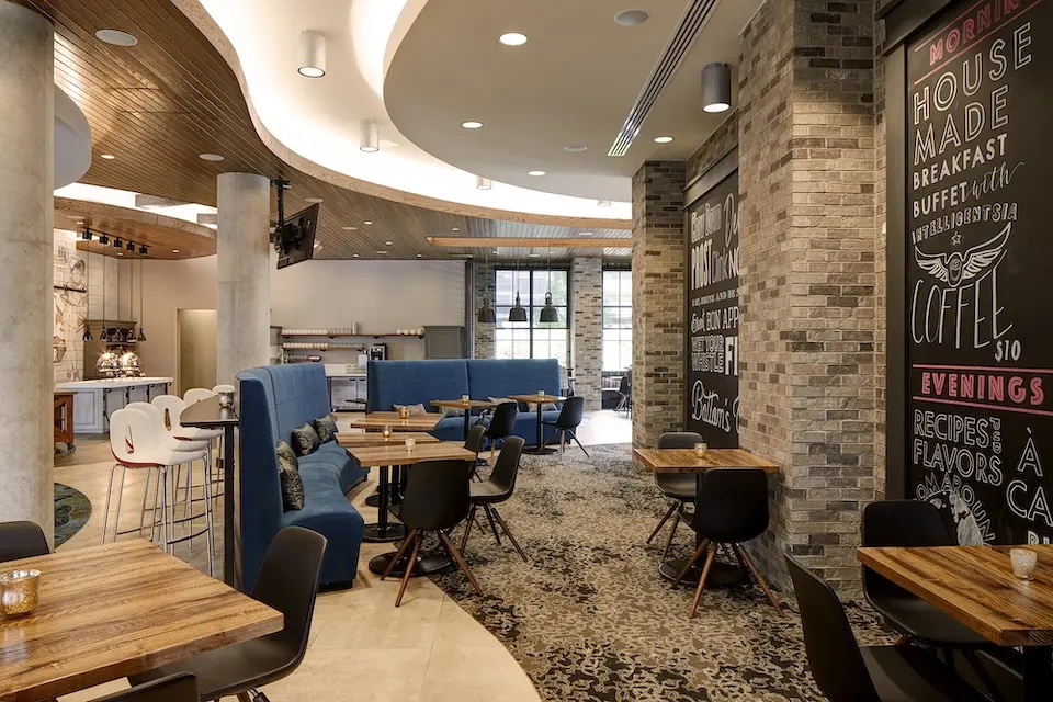 AKB - contemporary restaurant dining room featuring wooden tables, blue booths and a decorative chalkboard wall