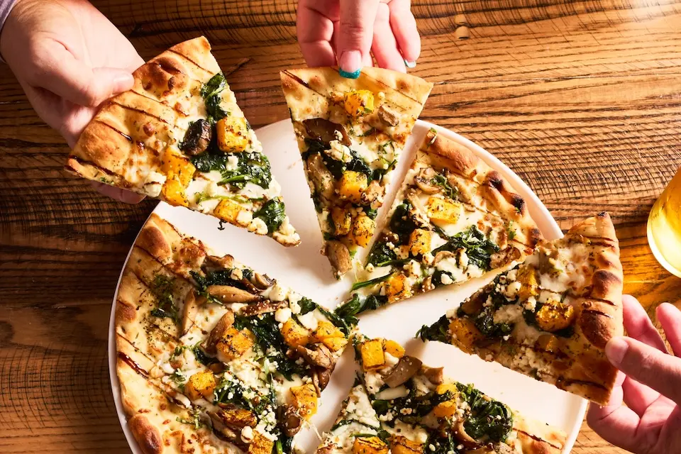 AKB - diners sharing a flatbread pizza during happy hour