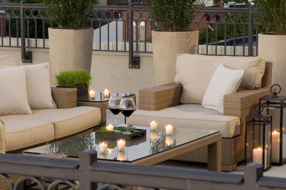 Outdoor soft seating with two glasses of wine and candles