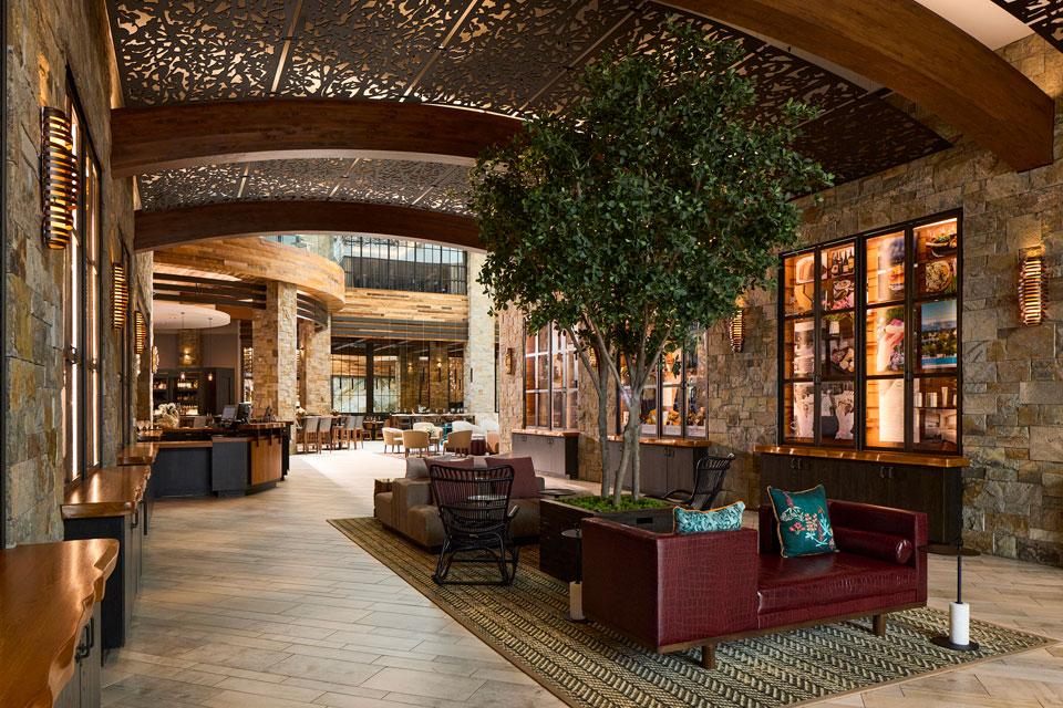 Wine-country-inspired lobby with barrel-like ceiling, lit tree and centered seating