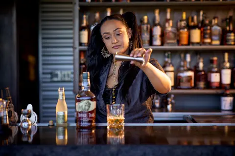 Female bartender pouring a drink at Sky & Vine bar