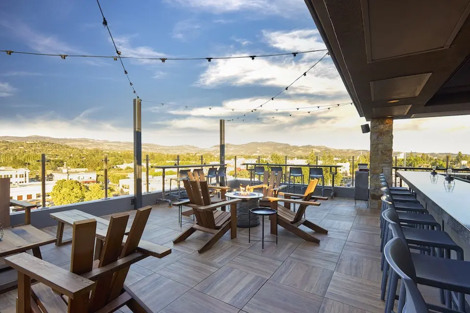 The Lookout - elevated alfresco gathering spot with a bar and stone fire pit overlooking Downtown Napa