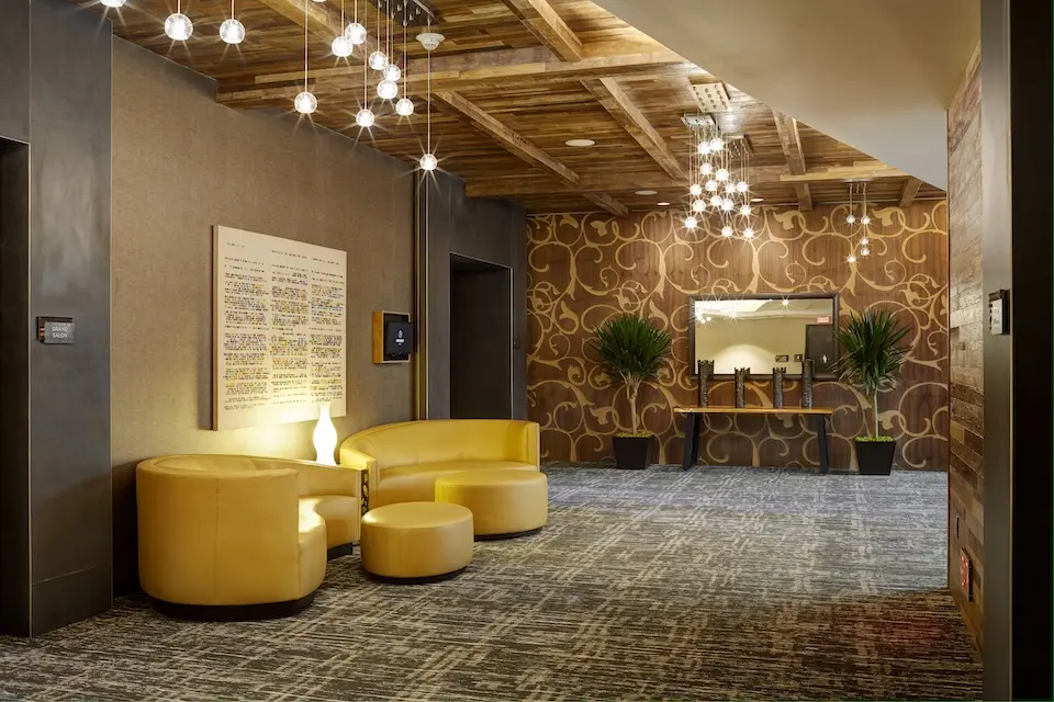 Grand Salon Foyer - prefunction space featuring warm walnut walls, storied art and comfy chairs
