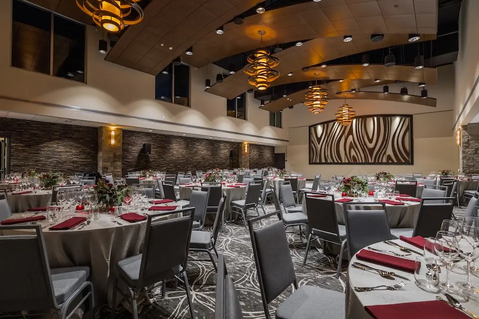 Grand Salon - banquet tables set with silver linens, red napkins and floral centerpieces under tiered pendant lights