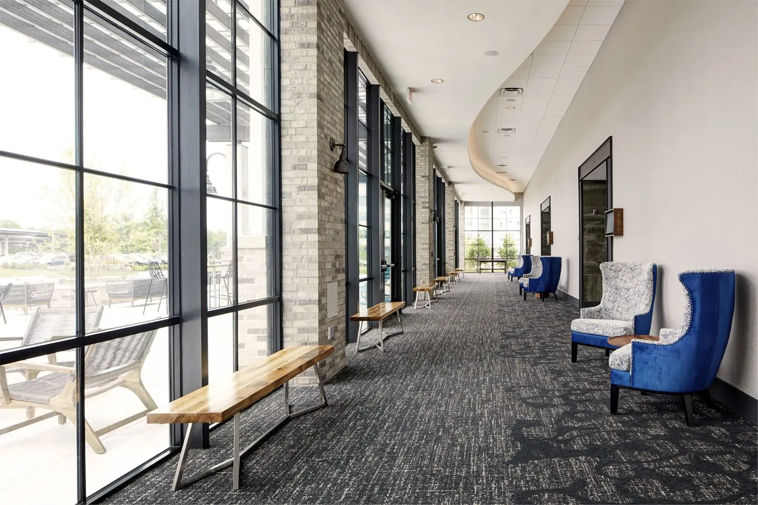 Great Room Foyer - open prefunction space furnished with deep blue wingback chairs and wooden benches