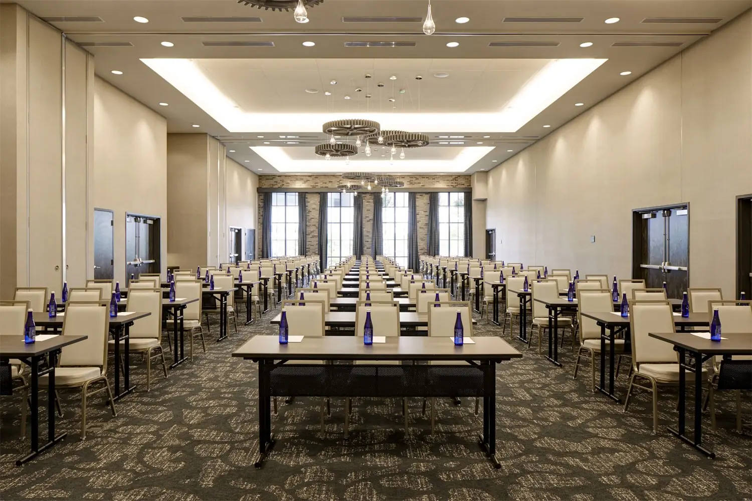 Great Room - corporate event with classroom table setup, bottled water and notepads