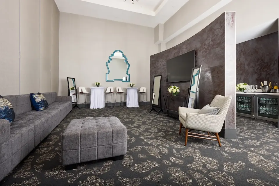 Hospitality Lounge - bridal suite featuring a gray modular sectional, table seating and a wet bar