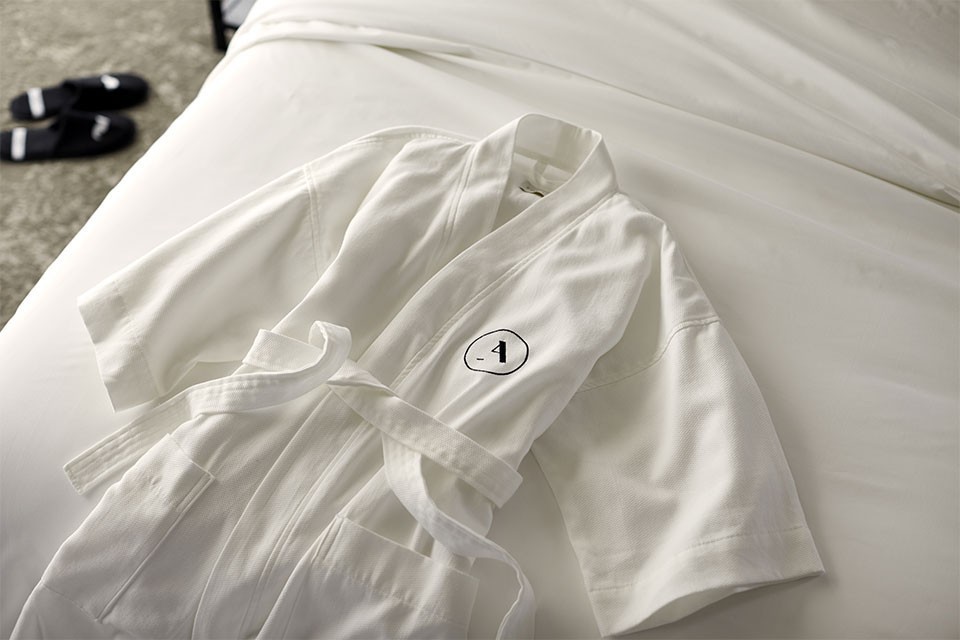 White Frette Archer robe on white bedding