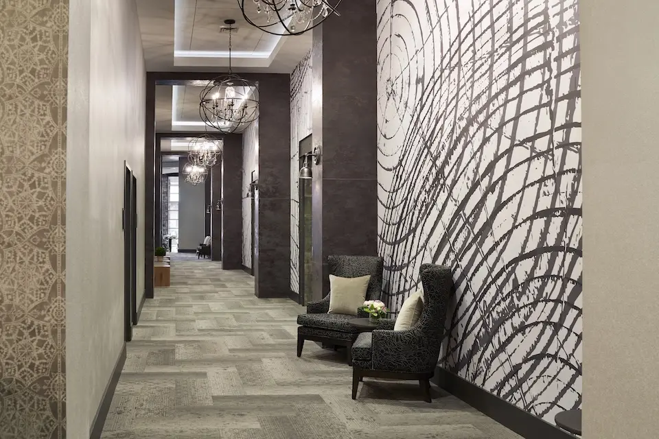 Great Room Foyer - carpeted prefunction space with two wingback chairs under sphere orb chandeliers
