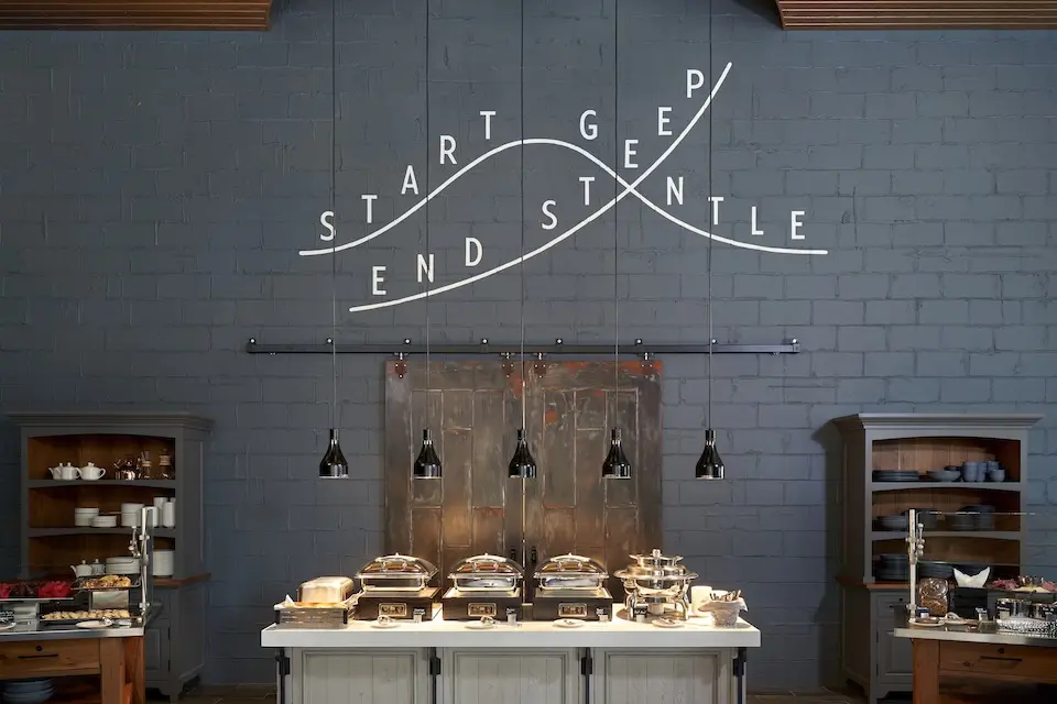 AKB - catering setup featuring a buffet table with appetizers and a graphic wall mural