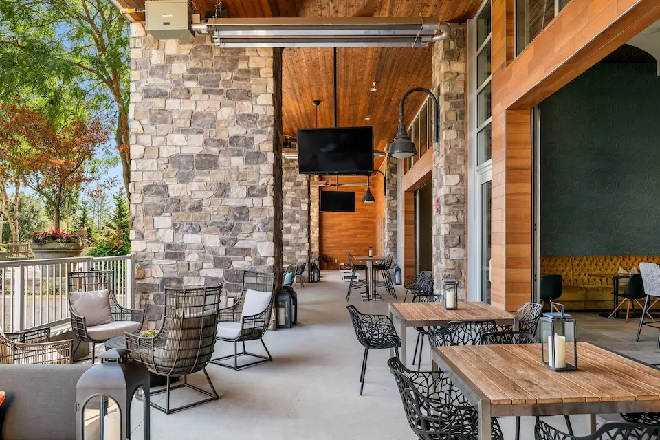 AKB - covered alfresco patio with table seating, overhead heaters and flat-screen TVs