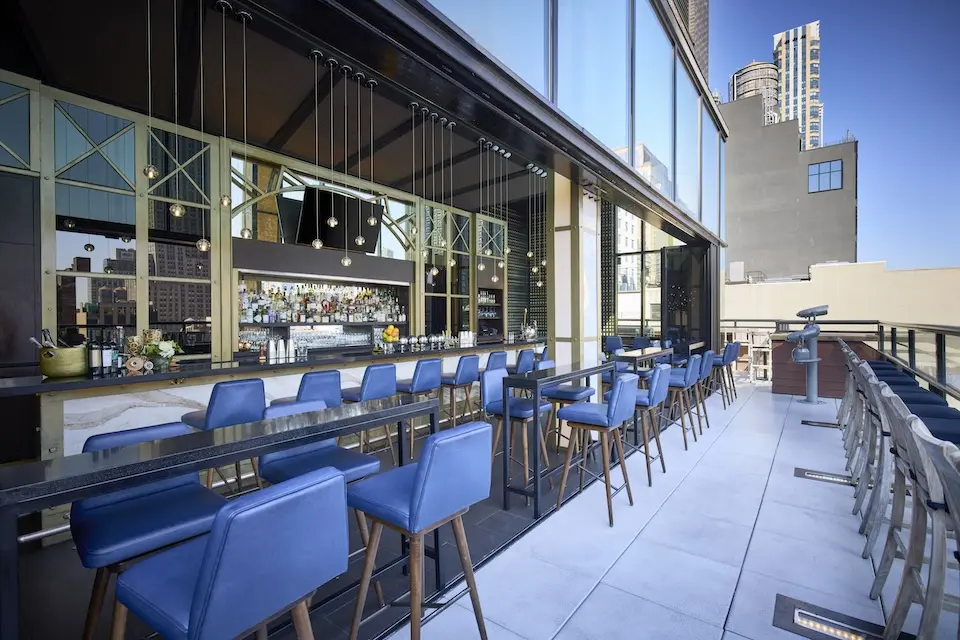 Spyglass - central bar with pendant lights, cobalt blue bar stools and an open-air terrace