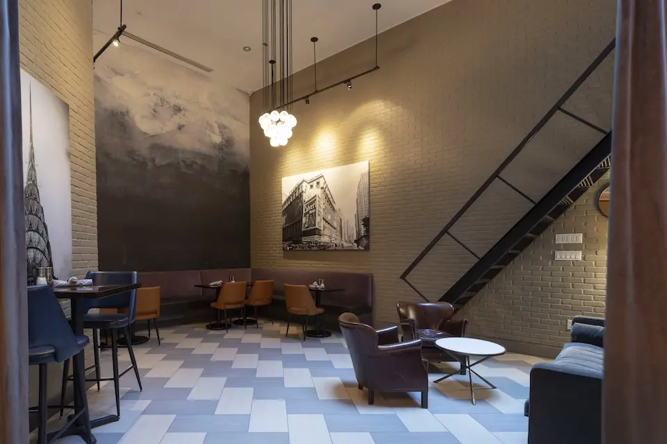 AKB - semiprivate lounge area with high ceilings, soft seating and Midtown Manhattan-inspired wall art