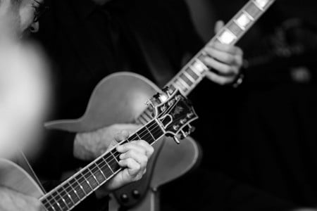 Black-and-white closeup of guitar players