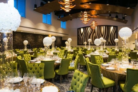 Venue with set tables, green chairs and white balloons