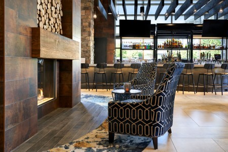Fireplace with seating and Archer's Kitchen + Bar in background 