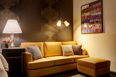 Deluxe King - ochre leather sofa with ottoman and wine-inspired artwork