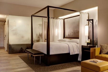 Archer King Balcony Suite - four-poster canopy-draped bed backdropped by Robert Buelteman's ethereal black-and-white Napa vineyard photograph