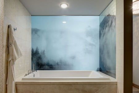 Archer King Balcony Suite - large soaking tub with a frosted bathroom wall