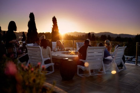 Archer's Rooftop — seating at the fire pit with a sunset skyline view