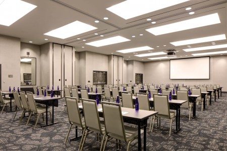 Great Room — Conference setup with tables and chairs, plus projector screen