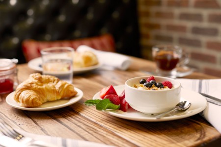 Breakfast at Archer's Kitchen + Bar — Croissant, coffee and yogurt with berries on table