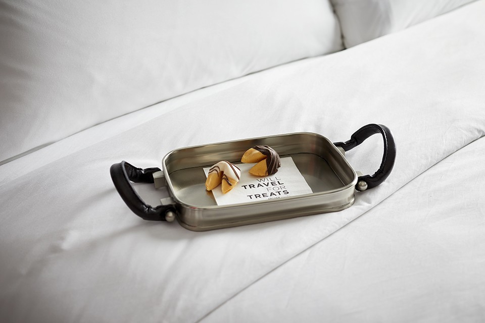 Turndown treat on bed - fortune cookies on a tray with a napkin