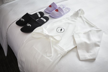 Whimsical slippers and Frette robe on bed