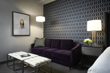 Archer King Suite - living area with mid-century modern eggplant sofa and coffee table