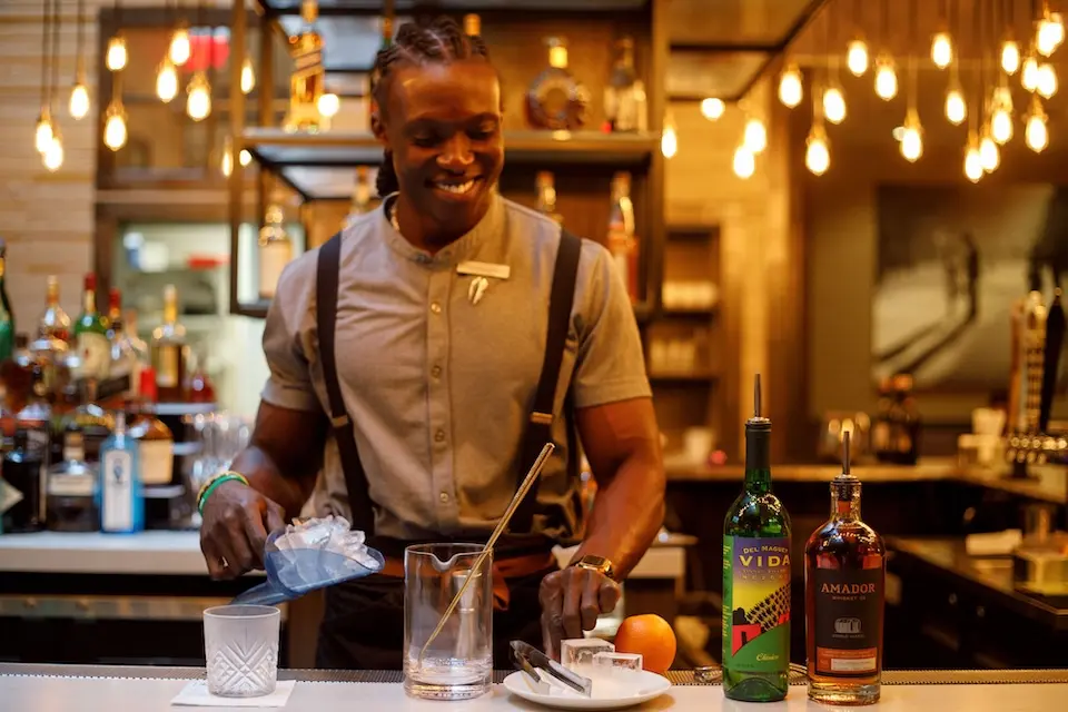 AKB - smiling bartender scooping ice to craft the signature Redemption cocktail