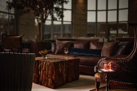 Leather lounge seating and rustic wood table at AKB in Archer Hotel Austin