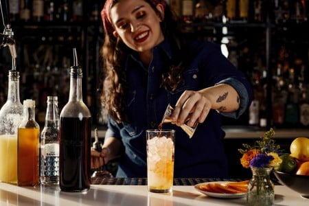 A bartender making a Violet Sky cocktail at AKB in Archer Hotel Austin