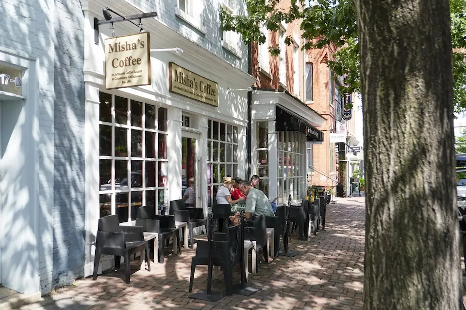 Old Town Alexandria - people sitting in chairs outside of a coffee shop along red brick sidewalks