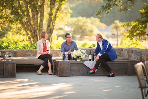 Two Men and A Woman Seating on a Terrace Drinking Wine 