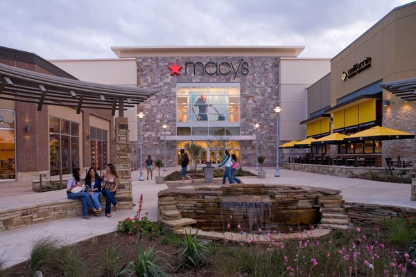 Macy's front entrance with water fountain and people socializing 