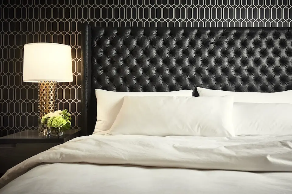 Archer King Suite - bedding detail with bedside lamp and large headboard