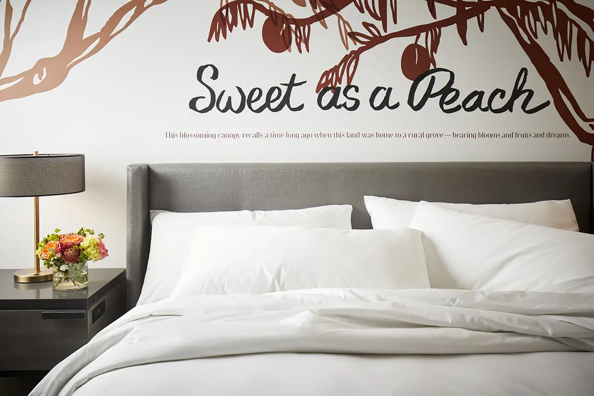 Classic King - turned down bedding with 'Sweet as a Peach' mural behind headboard