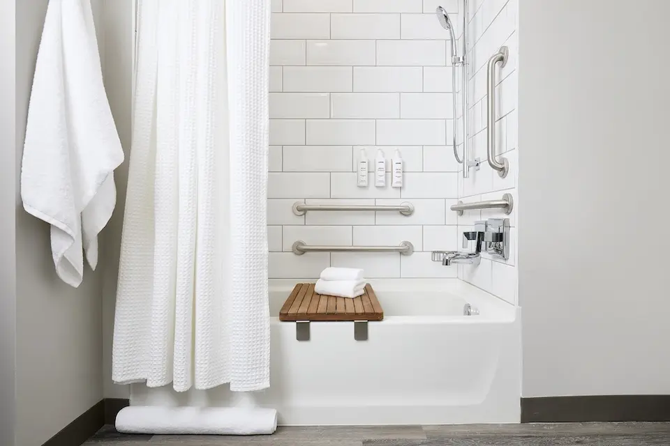 Double King - mobility-accessible tub with grab bars and hand-held shower wand