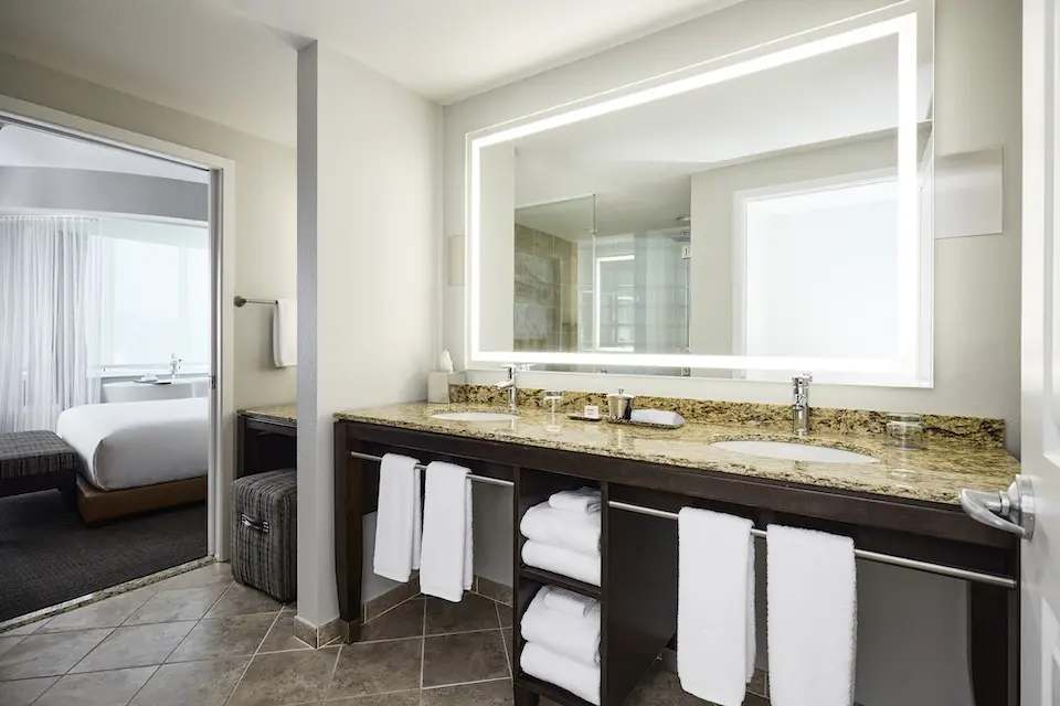 The Grand Den - large granite vanity and second makeup vanity with luxury bath amenities and lighted mirrors