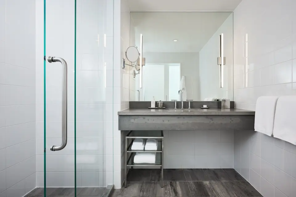 Balcony King - modern, white-tiled bathroom with walk-in shower and gray concrete vanity