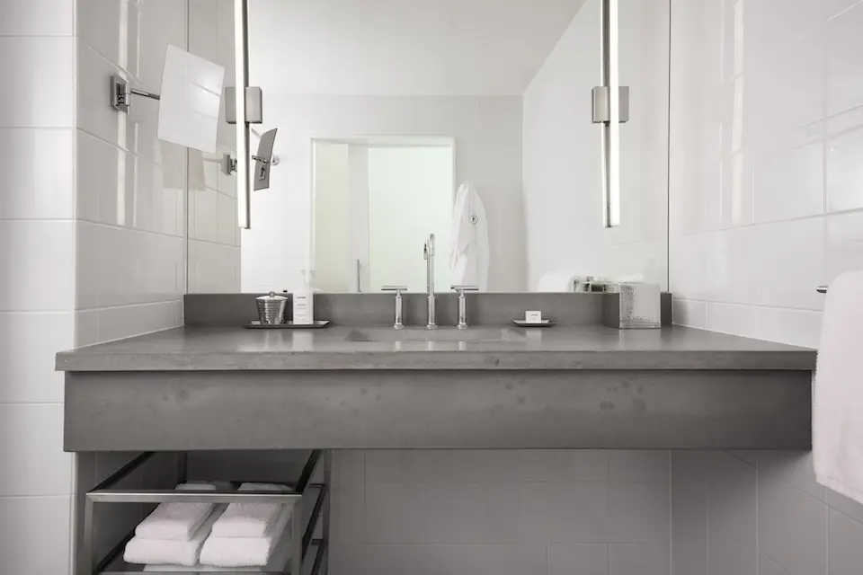Balcony King - modern bathroom with gray concrete vanity, mirror and luxury bath amenities