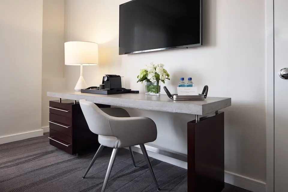 Balcony King - oversized concrete desk with welcome amenity and wall-mounted TV