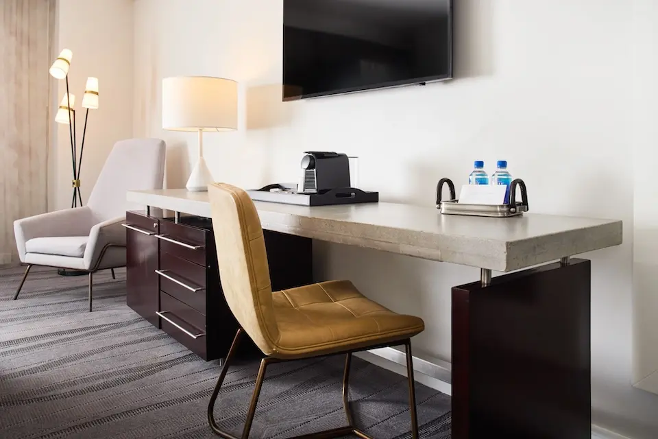 Corner King - oversized concrete work desk with seating and wall-mounted TV