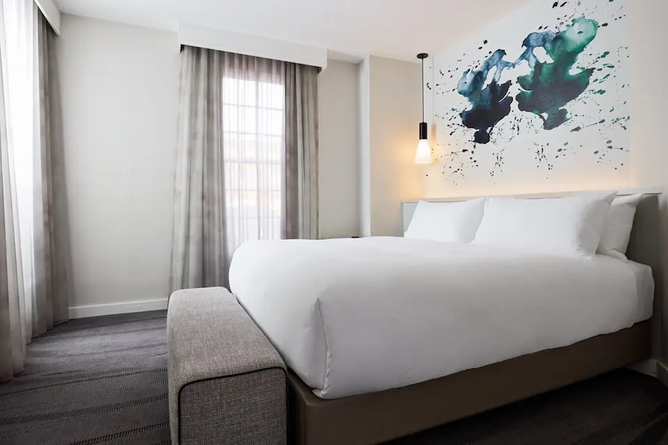 Archer's Den - private bedroom with platform bed featuring white five-star bedding