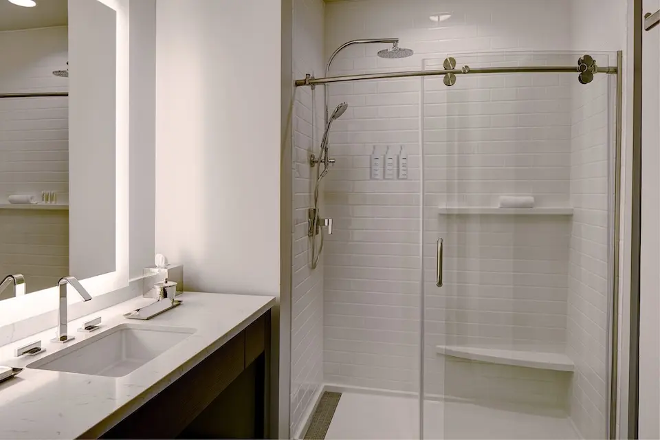 Archer’s Den - modern bathroom with vanity and white subway-tile walk-in shower