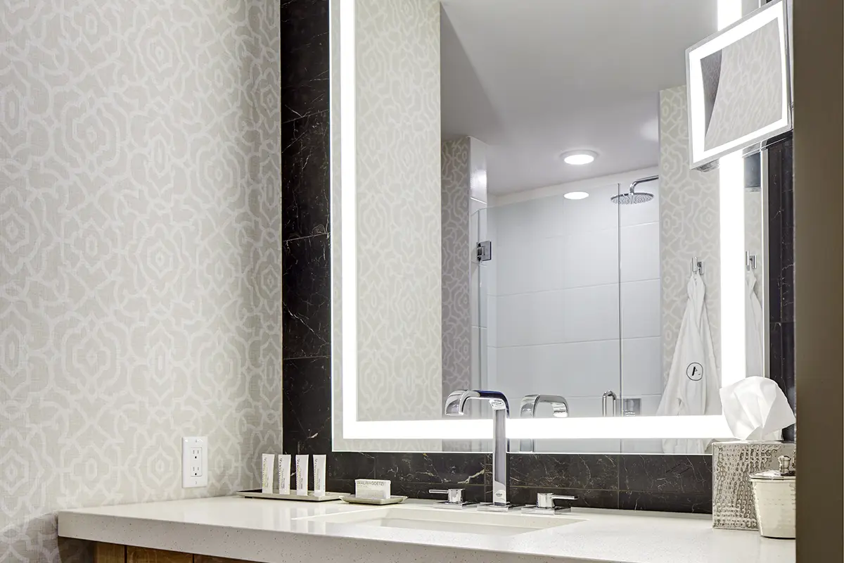 Elegant bathroom vanity with backlit mirror and luxury bath amenities