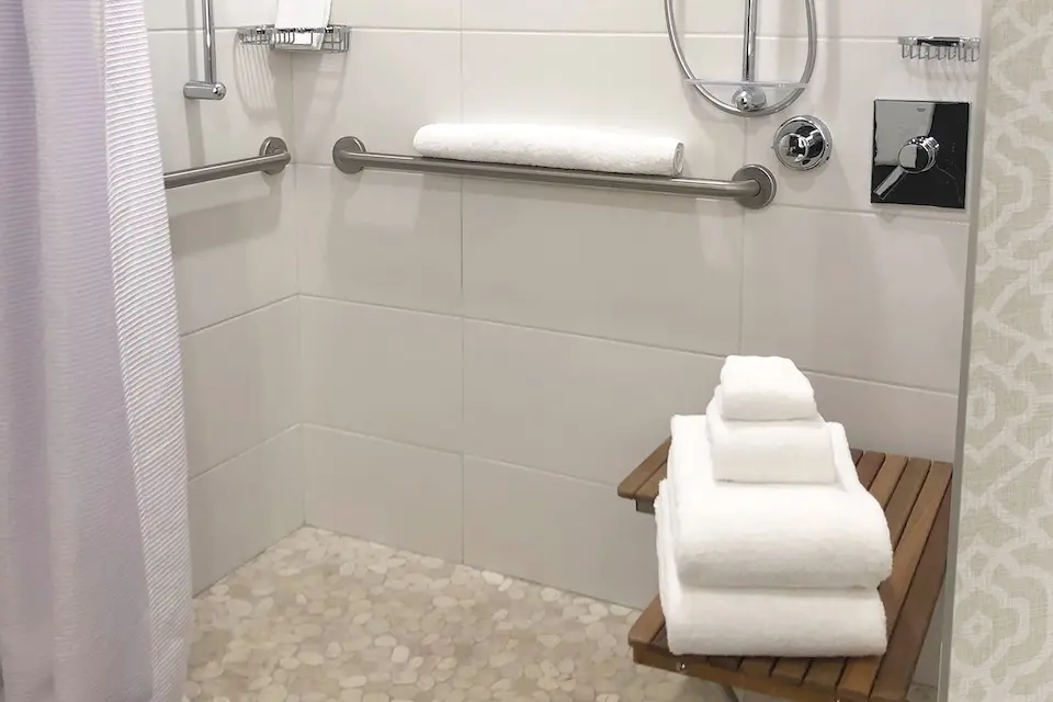 Classic King - mobility-accessible roll-in shower with grab bars, shower seat and hand-held shower wand